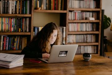 Child looking at a laptop in a library